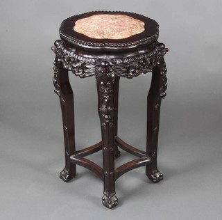 A circular Chinese pierced hardwood jardiniere stand with pink veined marble top, raised on carved supports with shaped stretcher 63cm x 34cm 