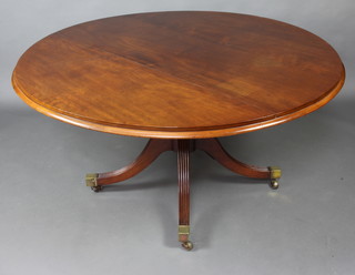 A 19th Century circular snap top dining table raised on gun barrel and tripod base with brass caps and casters 74cm h x  147 cm diam. 