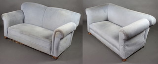 A pair of Edwardian drop arm sofas upholstered in blue material raised on bun supports 76cm h x 169cm w x 80cm d 