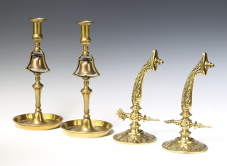A pair of 19th Century brass candlesticks fitted bells to the centre and raised on circular bases 32cm x 15cm together with a pair of Victorian polished brass gas light brackets 26cm x 12cm 