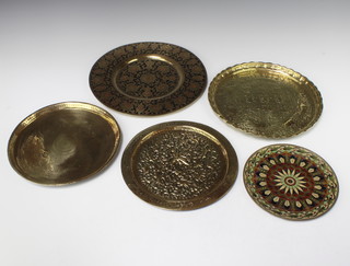 A circular Eastern embossed charger 25cm, 1 other 29cm together with 2 Benares brass ditto 31cm and 25cm and a brass and enamelled ditto 20cm 