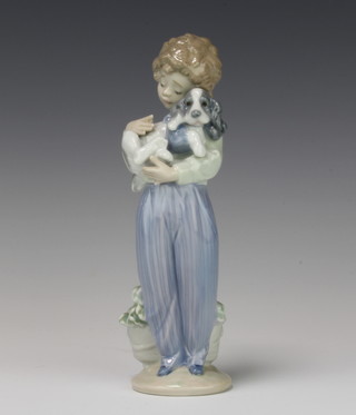 A Lladro figure of a young boy holding a puppy, for the Lladro Collectors Society 1989, 21cm 