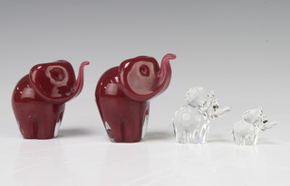 A Langham pink glass figure of a standing elephant 8cm, a ditto 7.5cm and 2 Swarovski Crystal elephants 