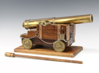 A brass cannon with 41cm barrel and drilled vent, raised on a stepped wooden carriage with brass wheels, complete with ram rod 