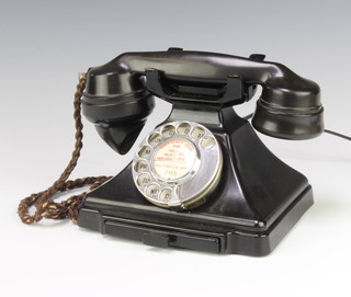 A black Bakelite dial telephone, the base marked FWR 55/2 