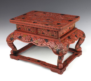 A rectangular red cinnabar lacquer stand of cushion form decorated birds and raised on cabriole supports 33cm x 43cm x 30cm