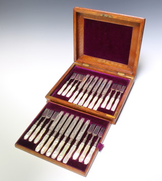 An Edwardian oak canteen containing a set of 12 silver dessert eaters with mother of pearl handles, London 1902, maker William Hutton and Sons Ltd 