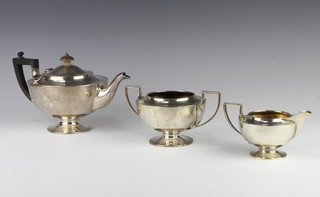 An Art Nouveau silver 3 piece pedestal tea set with ebony  mounts, London 1926, gross 1083 grams 