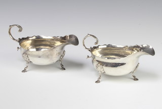 A pair of Edwardian silver sauce boats with cut rims and S scroll handles on hoof feet Sheffield 1902, 324 grams 