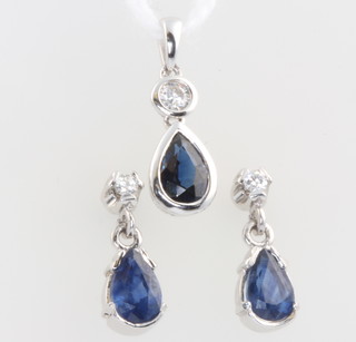 An 18ct white gold pear cut sapphire and diamond pendant together with a pair of ensuite ear studs 