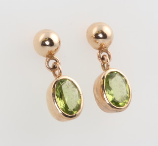 A pair of 9ct yellow gold oval peridot earrings 