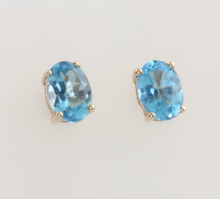 A pair of yellow gold oval topaz ear studs 7mm 