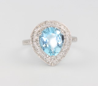 A 14ct white gold pear cut blue topaz ring approx. 4.42ct surrounded by brilliant cut diamonds approx 0.6ct, size N 
