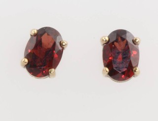 A pair of 9ct yellow gold oval garnet ear studs 