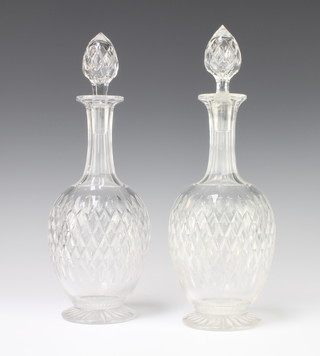 A pair of mallet shaped decanters and stoppers