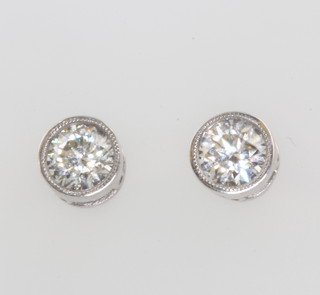A pair of 18ct white gold single stone rub over set diamond ear studs, approx. 0.67ct 