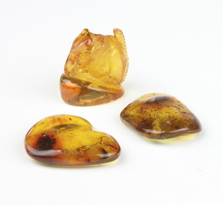 A carved amber figure of an animal 3cm, 2 pieces of amber 4cm 