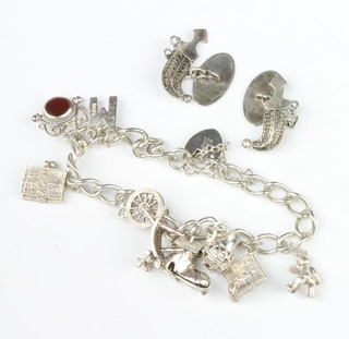 A silver charm bracelet and a pair of silver dagger cufflinks, 34 grams