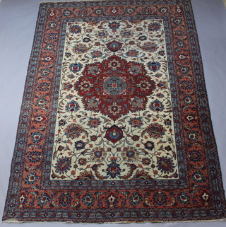 A brown, white and blue ground Persian Tabriz carpet with central medallion within a 6 row border