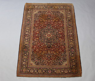 A brown, red and blue ground Persian Kashan rug with central medallion 