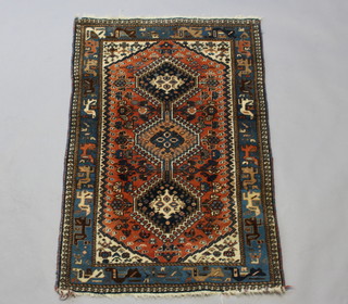 A blue and brown ground Persian rug with 3 diamonds to the centre within a multi row border 129cm x 85cm 