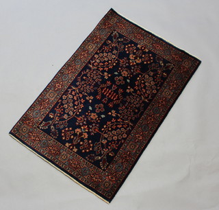 A blue and floral patterned Mohajeran rug within a 4 row border 94cm x 61cm 