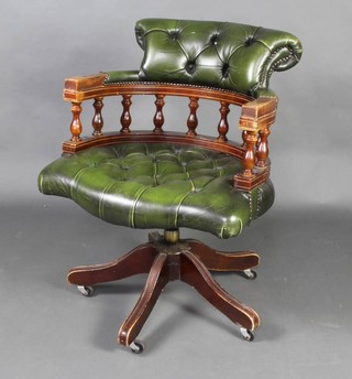 A Victorian style mahogany revolving desk chair, the seat and back upholstered in green buttoned leather 