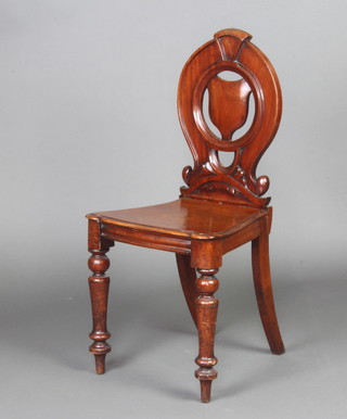 A Victorian mahogany hall chair with shield shaped back and solid seat raised on turned supports 