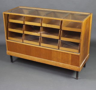 A light oak drapers display cabinet, fitted 12 drawers, raised on square metal supports 86cm h x 122cm w x 45cm 