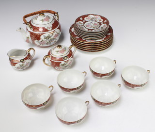 A Japanese tea set comprising saki pot, sugar bowl and cover, milk jug, 6 tea cups, 6 tea saucers and 6 small plates, the cups with lithophane bases 