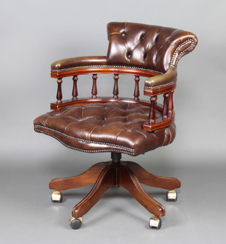 A Victorian style mahogany tub back revolving office chair with bobbin turned decoration, upholstered in brown buttoned leather