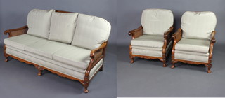 A 1930's walnut single cane 3 piece bergere suite comprising 2 seat settee and two armchairs, raised on cabriole supports 