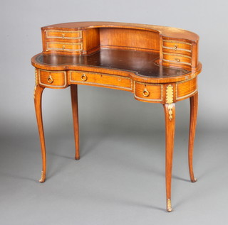 A 19th Century French kidney shaped satinwood writing table, the raised back fitted 4 drawers, the base fitted 1 long drawer flanked by 2 short drawers, having a black inset tooled leather writing surface, gilt metal mounts throughout, raised on cabriole supports 90cm h x 93cm w x 50cm d  
