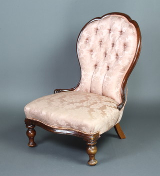 A Victorian mahogany show frame nursing chair, the seat and back upholstered in pink buttoned material, raised on turned supports 