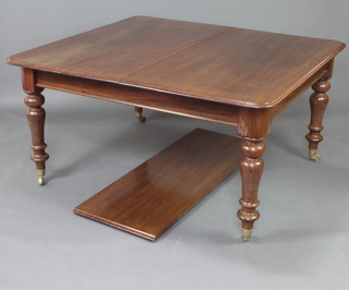 A Victorian mahogany extending dining table with 1 extra leaf, raised on turned supports ending in brass caps and casters, the interior fitted a box containing clips 77cm h x 129cm w x 141cm l x 190cm l when extended 