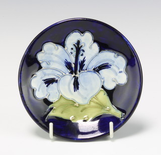 A Moorcroft circular dish decorated with blue hibiscus on a dark blue ground, impressed mark 12cm 