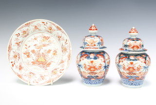 A pair of 19th Century Imari baluster vases and covers decorated with flowers 20cm together with an 18th Century Chinese ochre plate decorated a bird 21cm  