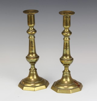 A pair of 19th Century brass candlesticks raised on octagonal bases with ejectors 25cm x 10cm 