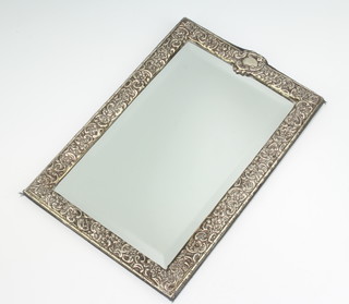 A Victorian style repousse silver framed mirror with floral and scroll decoration 26cm x 18cm 