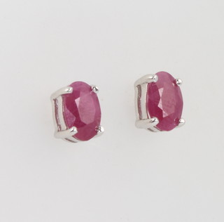 A pair of white gold oval ruby ear studs 7mm 