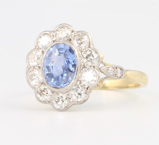 An 18ct yellow gold oval sapphire and diamond cluster ring, the centre stone 0.8ct surrounded by brilliant cut diamonds 1.5ct, size O 1/2