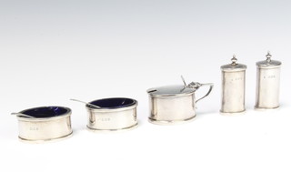 A stylish silver condiment set of cylindrical form comprising 2 peppers, 2 salts, a mustard and 2 spoons London 1920, 237 grams 