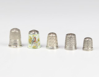 A silver and enamelled thimble decorated with a bullfinch and 4 other thimbles