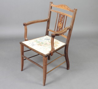 An Edwardian inlaid mahogany open arm chair with upholstered seat raised on outswept supports 