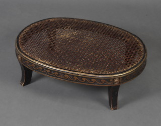 A Regency style ebonised and gilt painted oval stool with cane seat 20cm h x 66cm w x 49cm d, complete with cushion
