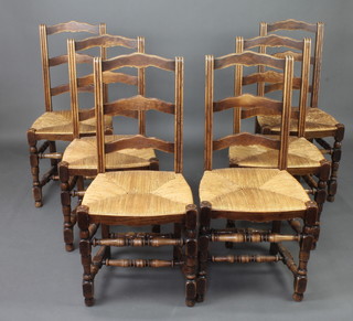 A set of 4 French elm ladder back dining chairs with woven rush seats 