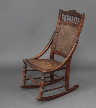 A Victorian beach framed rocking chair with bobbin turned decoration, caned seat and back, raised on turned supports 