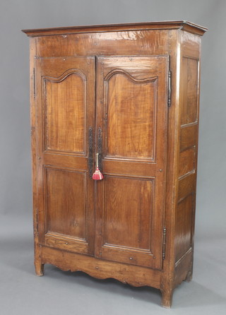 An 18th Century Continental oak and fruitwood cabinet with shelved interior enclosed by a pair of arched panelled doors 178cm h x 16cm w x 39cm 