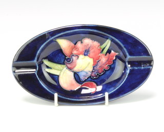 A Moorcroft oval ashtray decorated flowers against a blue ground, having a Princess Mary label 16cm 
