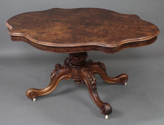 A Victorian shaped figured walnut Loo table raised on a carved column base 72cm h x 142cm w x 106cm d 